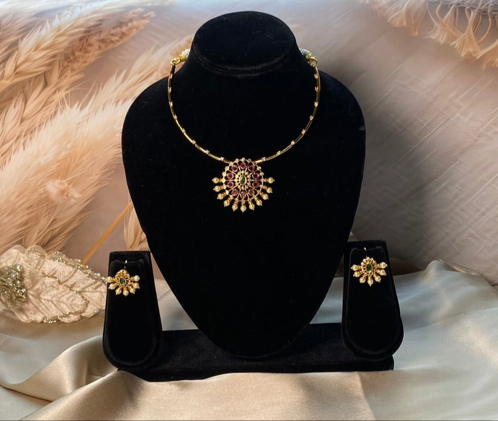 Ruby and emerald-toned stone accents for vibrant charm.