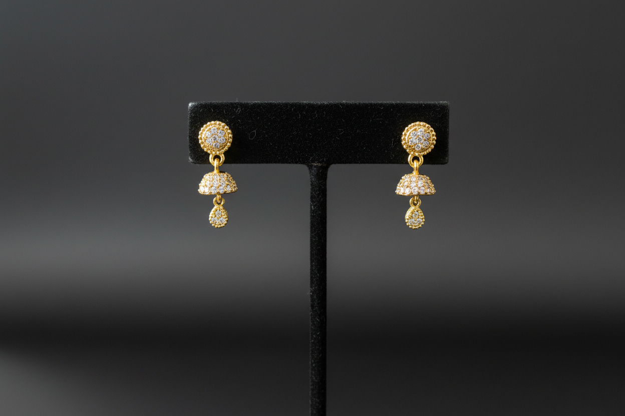 Gold drop earrings on display stand