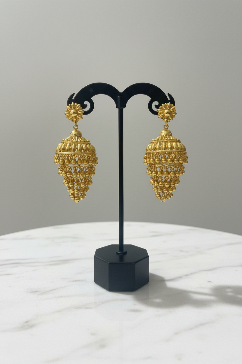 Gold jhumka earrings on display stand