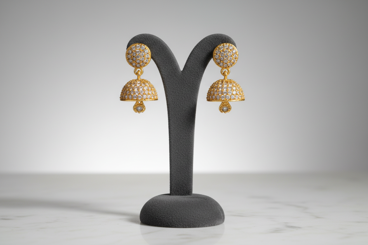 Gold jhumka earrings on display stand
